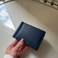 Billetera Dante de Maison Caviar en cuero negro con detalles elegantes y compartimentos para tarjetas y dinero.
