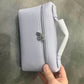Bolso Giulia de Maison Caviar en cuero negro con asas cortas y detalles elegantes, perfecto para ocasiones especiales.