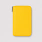 Billetera Greta de Maison Caviar en color amarillo, con diseño compacto y cierre elegante, ideal para llevar tarjetas y dinero.