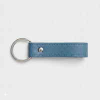 Llavero Maison Caviar Capri en color azul oscuro, con diseño elegante y detalles en forma de llavero.