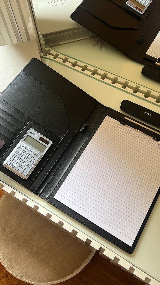 Portafolio Maison Caviar Cassio Amadeo de cuero negro con cierre y compartimentos internos para documentos y accesorios.