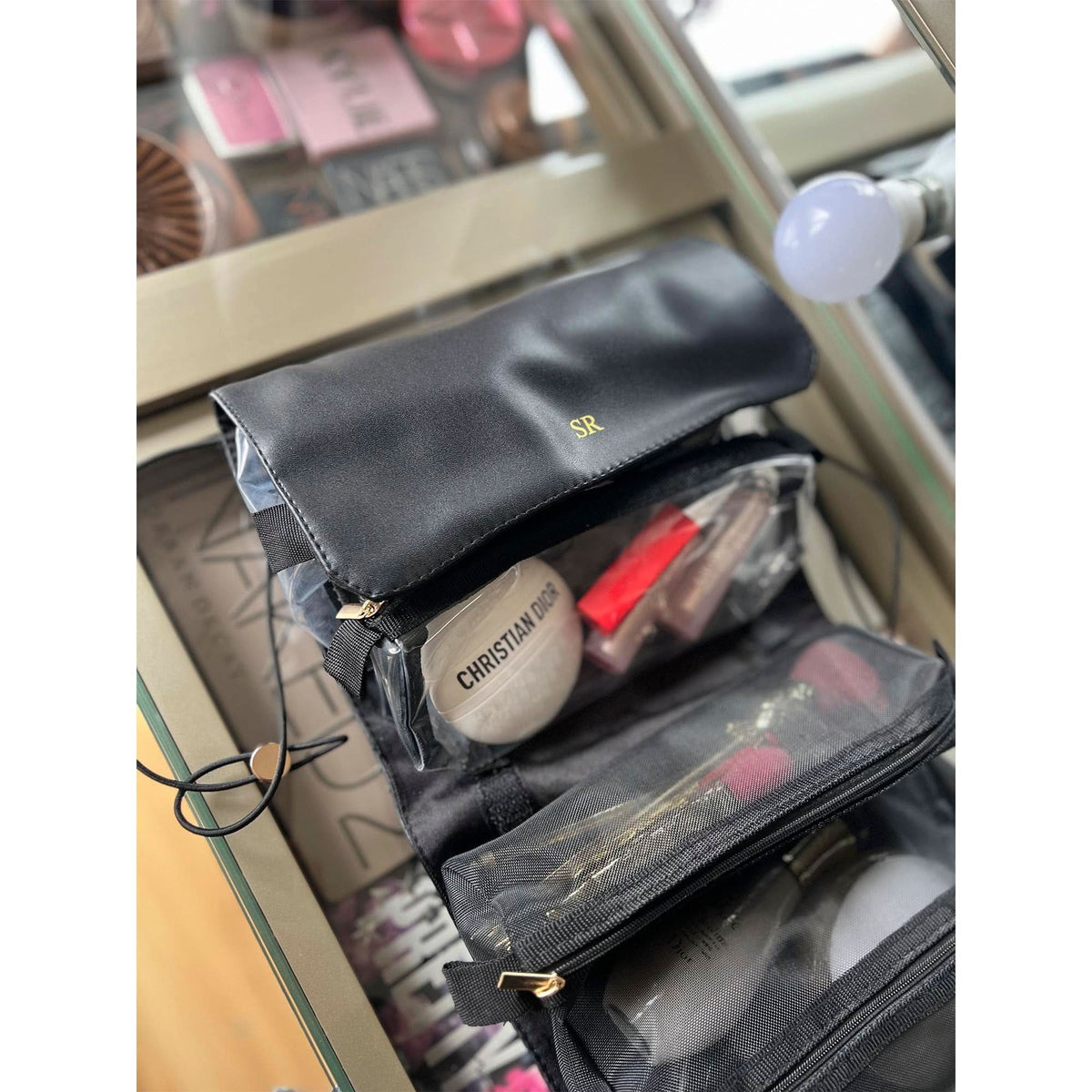 Neceser de maquillaje Maison Caviar Enzo con compartimentos y asa, diseño elegante en cuero negro para viajes y almacenamiento de belleza.
