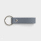 Llavero Maison Caviar Capri en color gris azulado con diseño elegante y detalles en piel sintética.