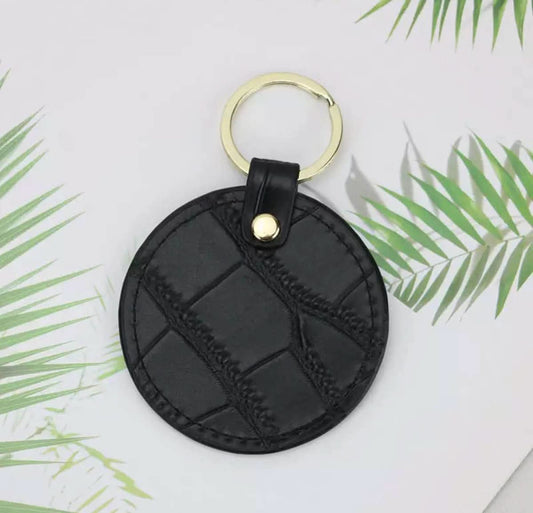 Llavero Maison Caviar Lyon de cuero con detalles dorados, muestra el diseño elegante y sofisticado del accesorio.