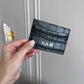Tarjetero Maison Caviar Cannes de cuero negro con compartimentos para tarjetas y diseño elegante.