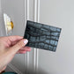 Tarjetero Maison Caviar Cannes en cuero negro con múltiples ranuras para tarjetas y cierre elegante.