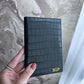 Porta pasaporte Maison Caviar Egeo de cuero negro con detalles en dorado, diseñado para proteger y organizar pasaportes.