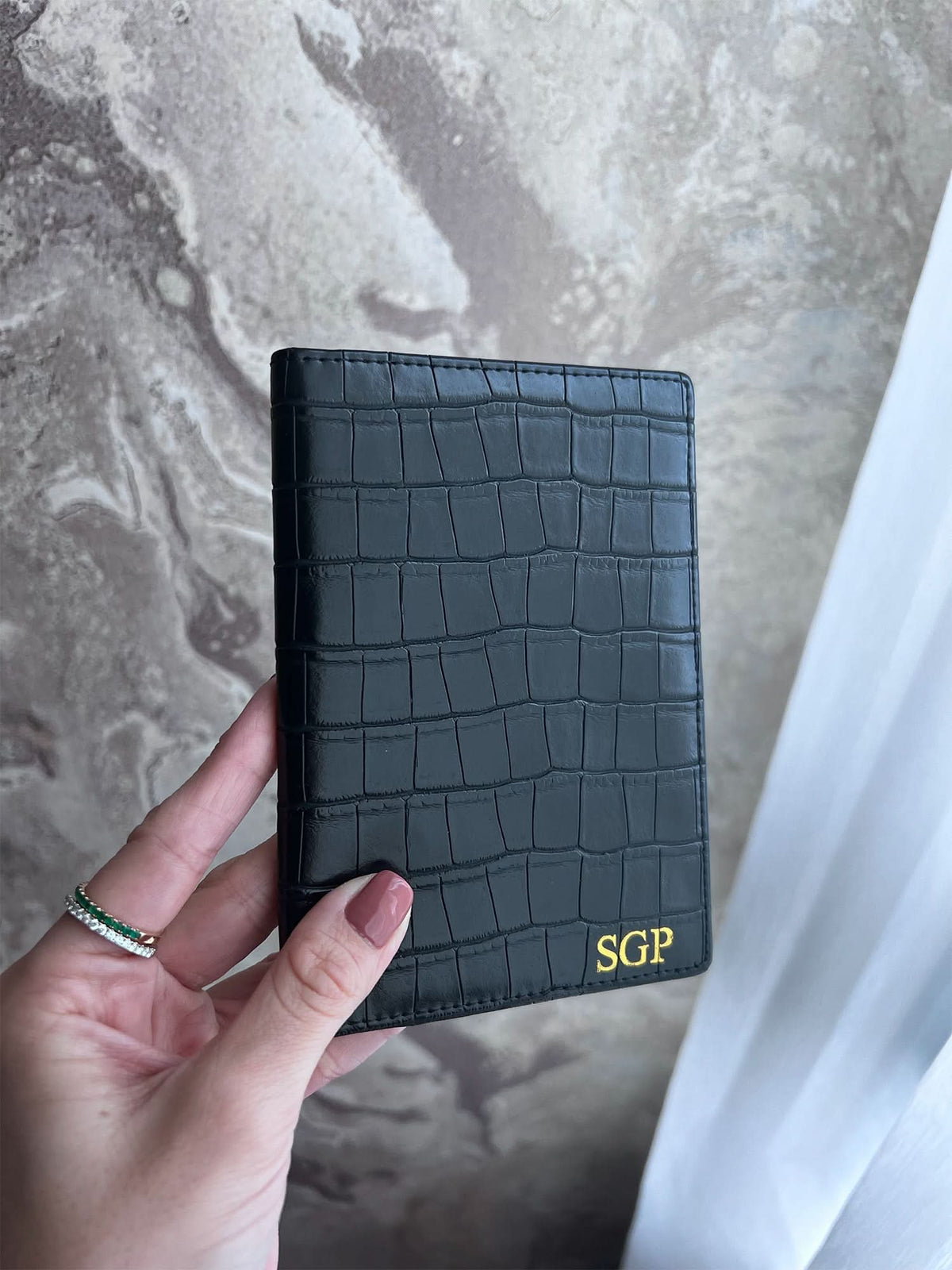 Porta pasaporte Maison Caviar Egeo de cuero negro con detalles en dorado, diseñado para proteger y organizar pasaportes.