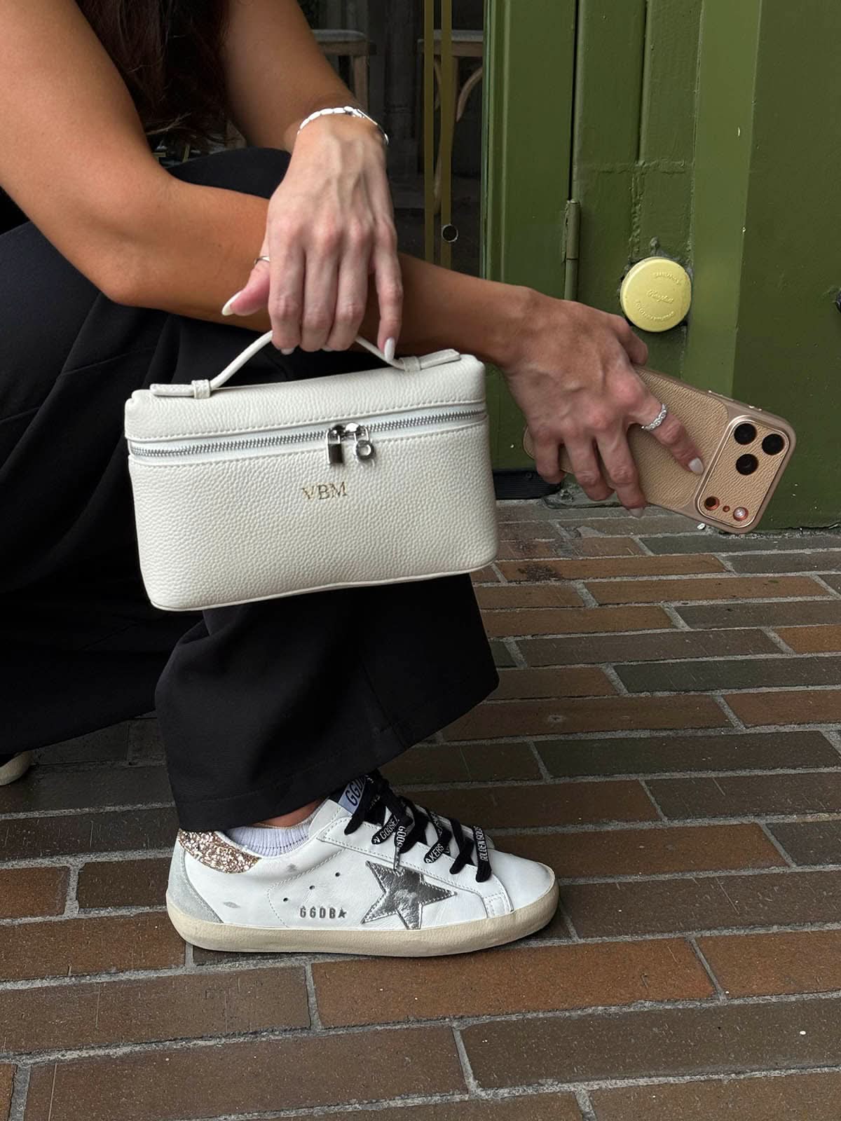 Bolso Giulia de Maison Caviar, bolso de mano en cuero con detalles elegantes y asa superior, sobre fondo neutro.