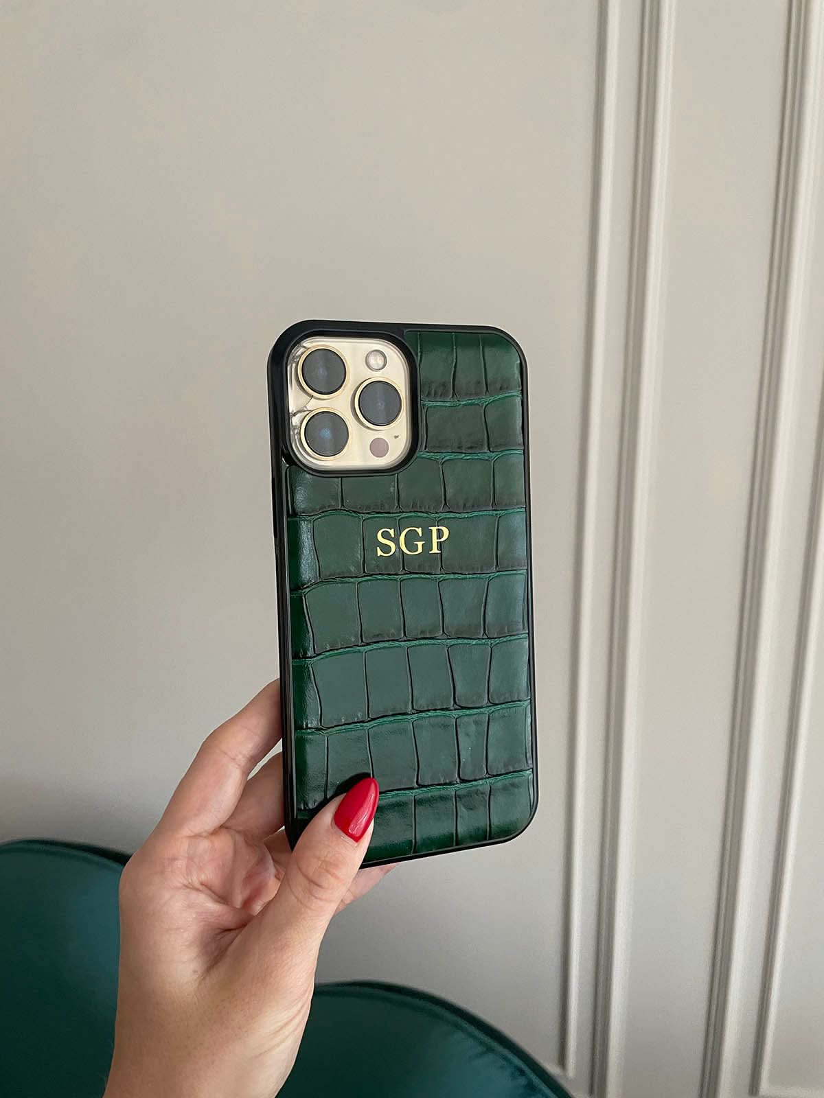 Funda para iPhone Siena de Maison Caviar, protección elegante en cuero con detalles en dorado sobre fondo oscuro.