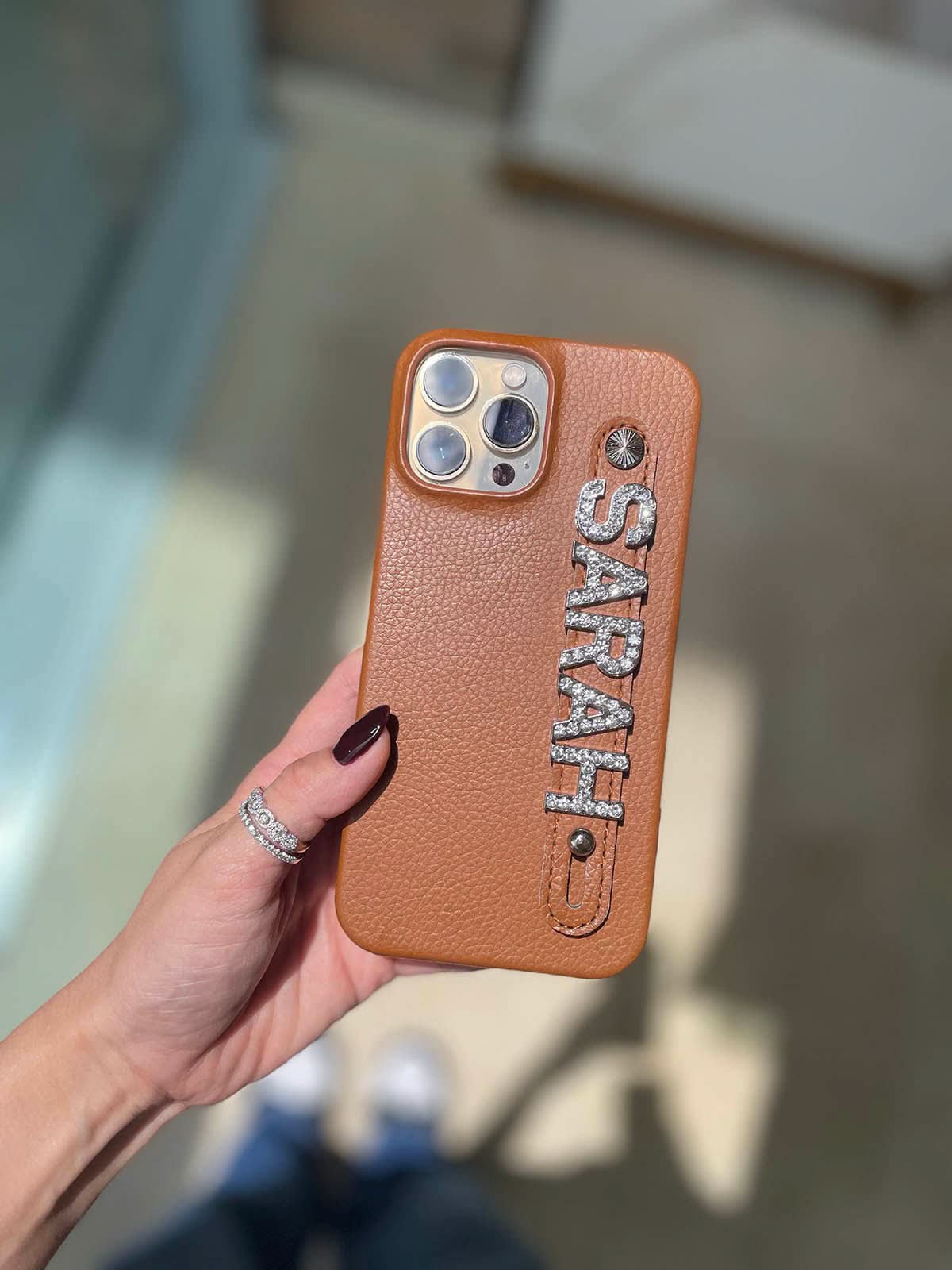 Funda para iPhone Celine de Maison Caviar, protección elegante con diseño sofisticado, en color negro con detalles dorados.