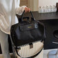 Bolso Salvatore de Maison Caviar, bolso de cuero negro con detalles elegantes y asas cortas, en una vista lateral.