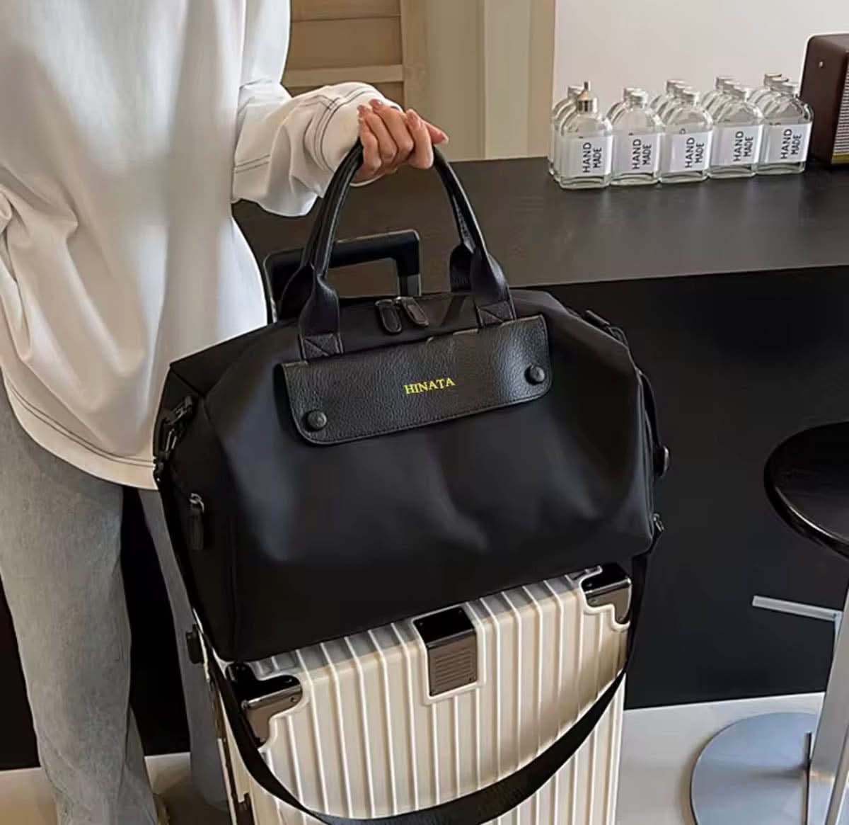 Bolso Salvatore de Maison Caviar, bolso de cuero negro con detalles elegantes y asas cortas, en una vista lateral.