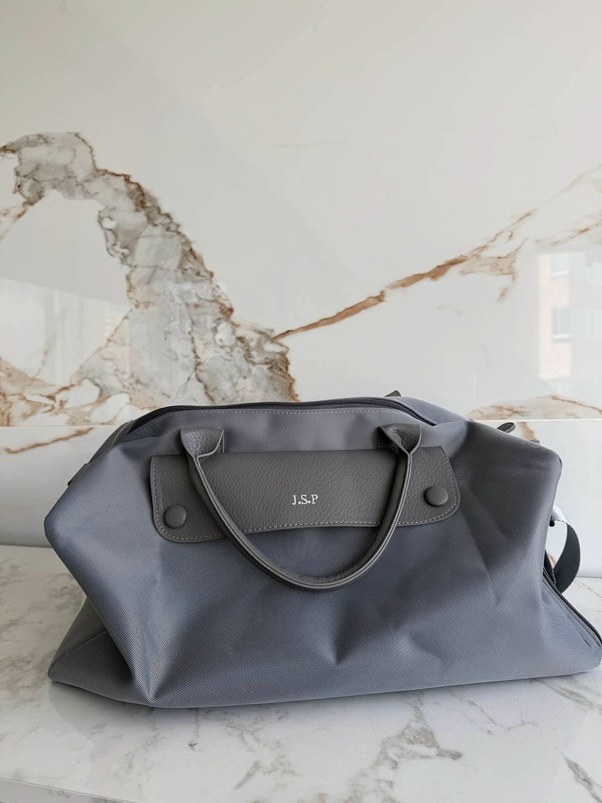 Bolso Salvatore de Maison Caviar, bolso de cuero negro con asa superior y detalles elegantes, en una vista frontal.