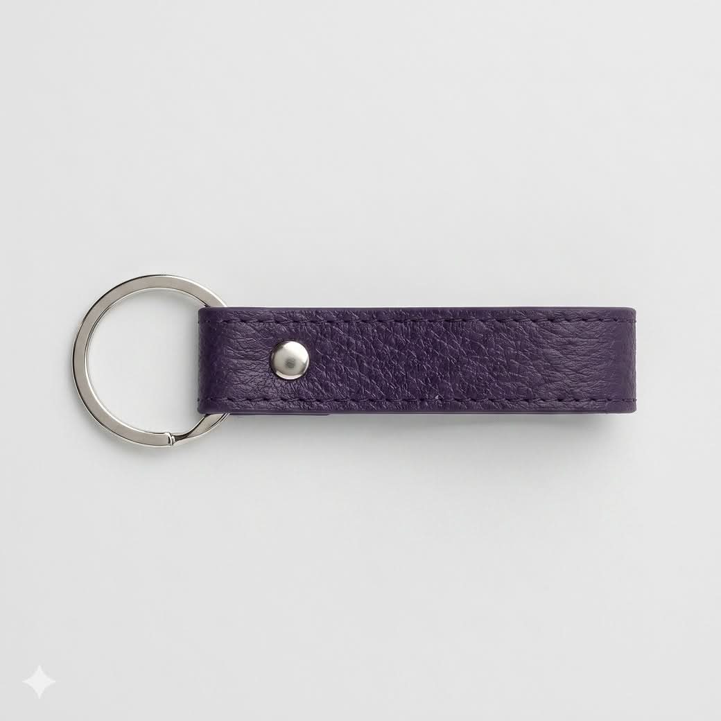 Llavero Maison Caviar Capri en color morado con diseño elegante y detalles en la superficie, para llaves y accesorios.