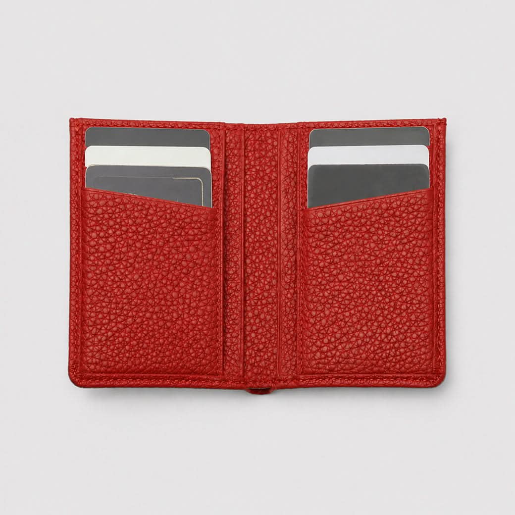 Billetera roja Maison Caviar Alphonse, hecha de cuero elegante, con compartimentos internos visibles.