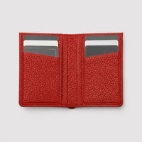 Billetera roja Maison Caviar Alphonse, hecha de cuero elegante, con compartimentos internos visibles.